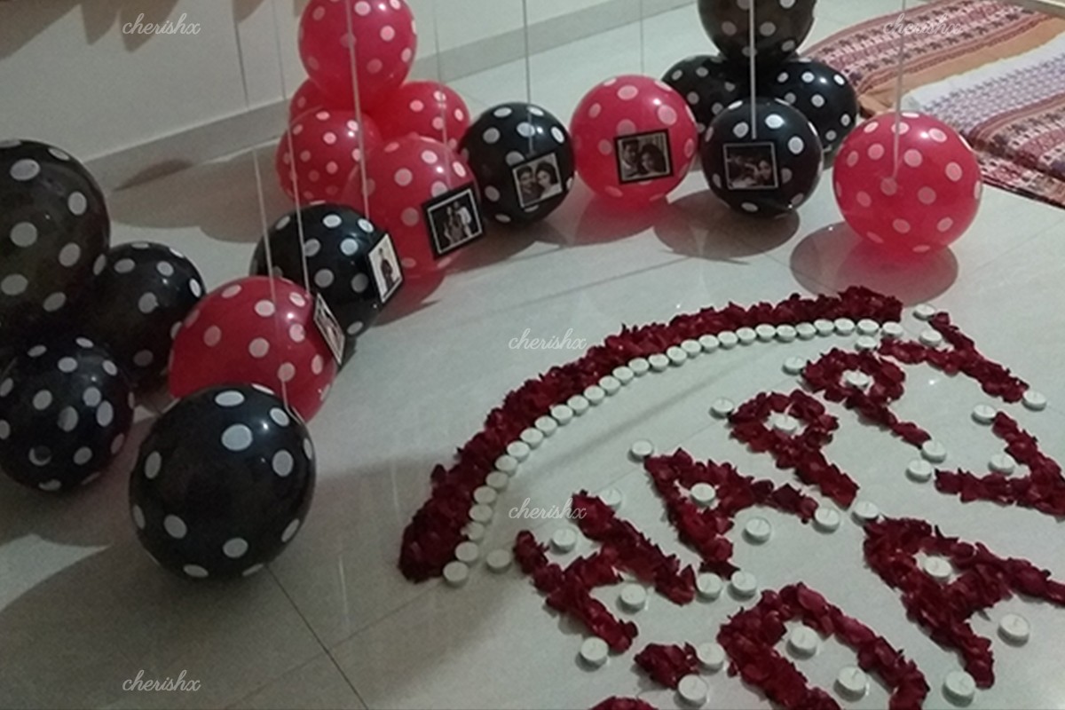 A decorated room with balloons, photos and candles for a midnight Birthday surprise.