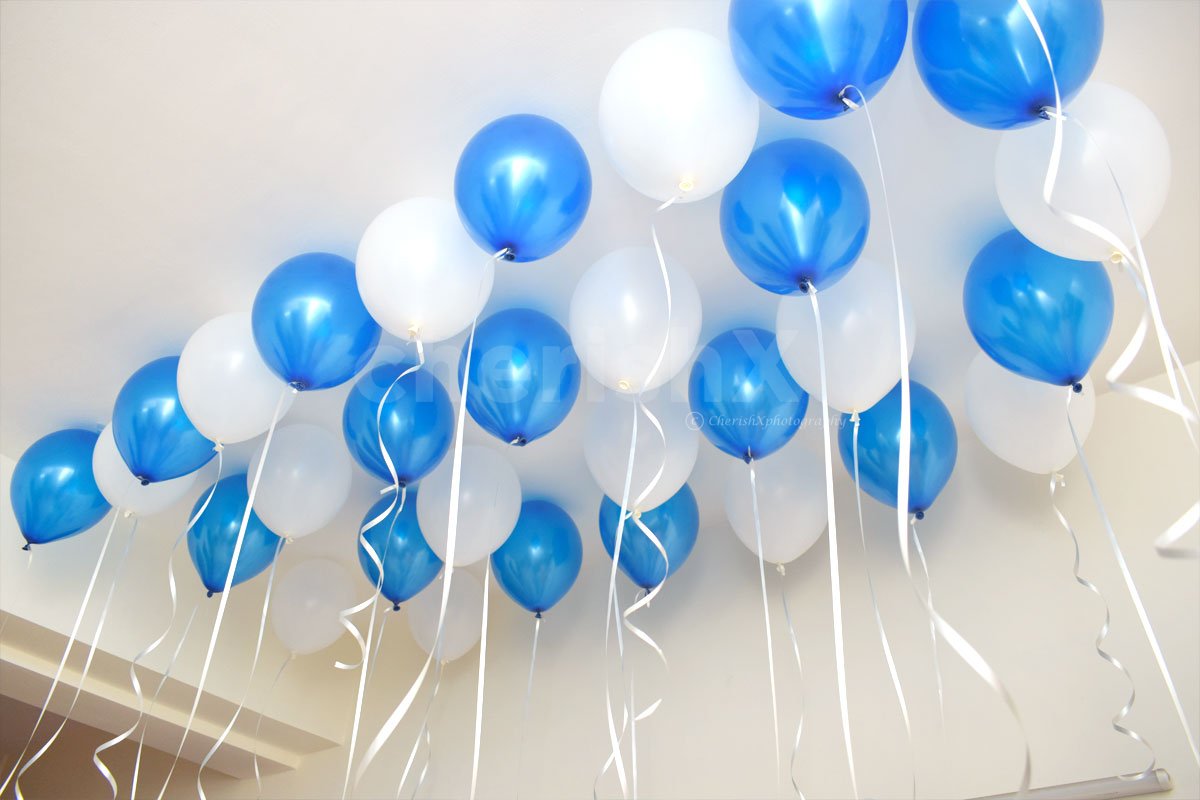 The ceiling is filled with blue and white balloons to give an appealing look to the whole room.