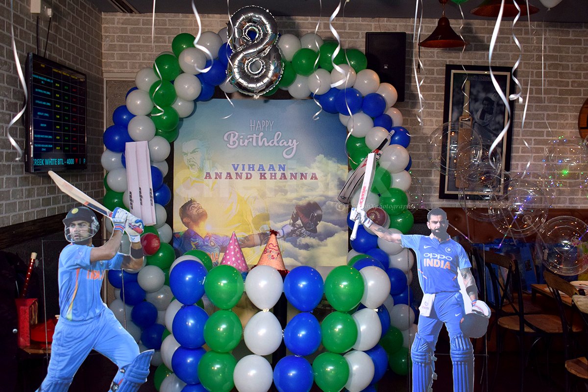 Balloon arc, a backdrop and cricket personality cut-outs for a photo booth.