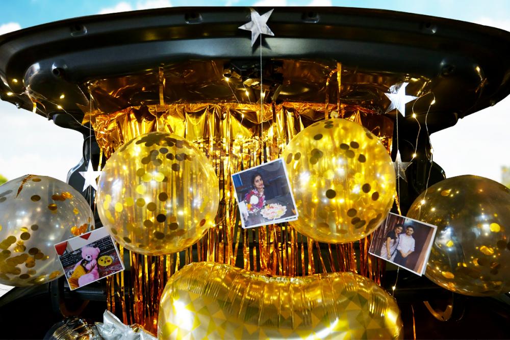 A Car Boot Decor offered by CherishX filled with balloons and personalised photos.