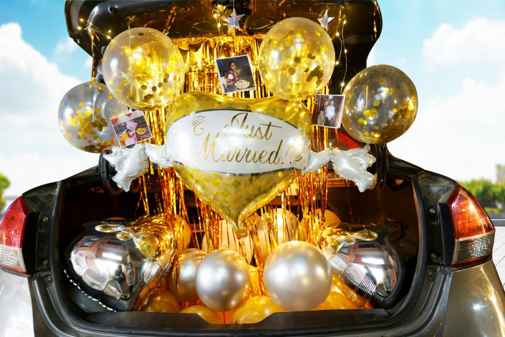 A Car Boot Decor filled with Balloons, photos and lights.