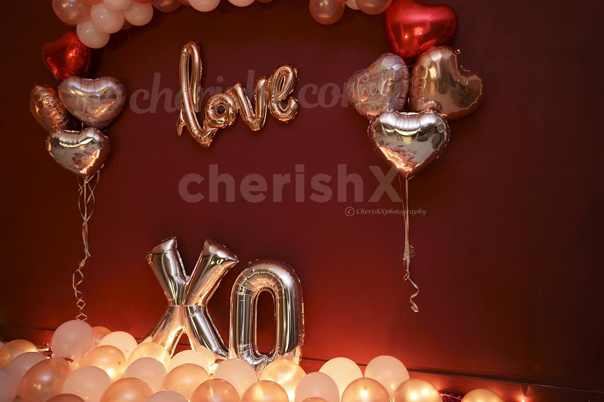 The decor consists of wall decor with balloons. Moreover, there are balloons spread out on the floor to enhance the room decor.