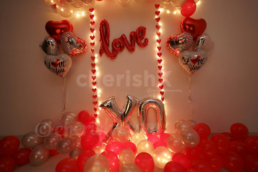 The overall room decoration with balloons spread out on the floor as well as glued to the wall.