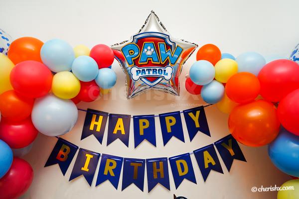 Silver star shaped foil balloon with PAW Patrol Badge Sticker on it.