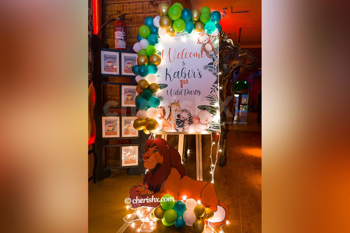 Theme based Welcome Board (3x2ft) with Easel Stand decorated with a balloon arch.