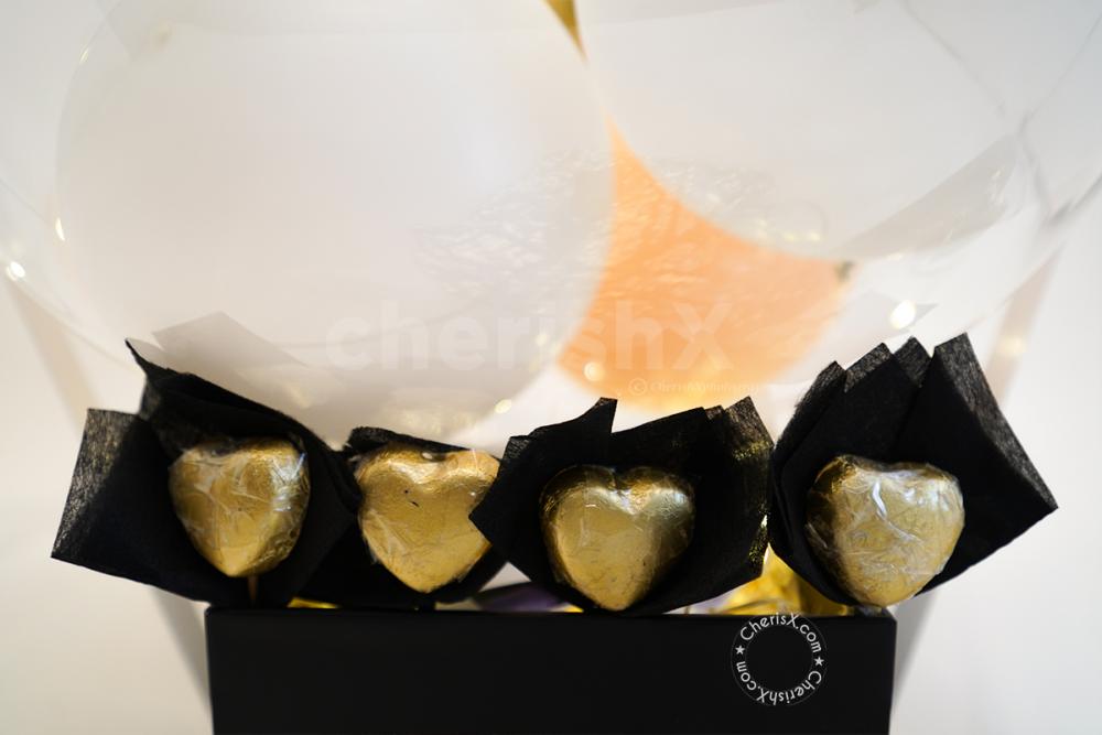 Heart- Shaped Golden Chocolates kept inside the Helium Surprise Bucket for Karwa Chauth!