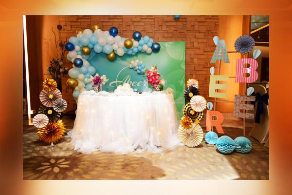 6x8ft Personalized flex decorated with a balloon arch of colours Pastel Blue, White Latex, Blue Chrome and Golden Chrome Balloons.