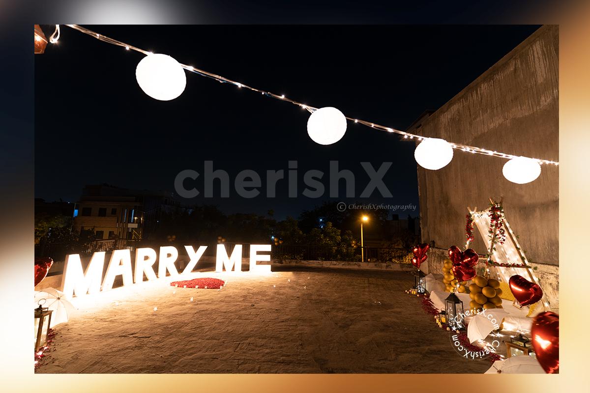 Grand Marry Me Led Letters places with heart made with red rose petals.