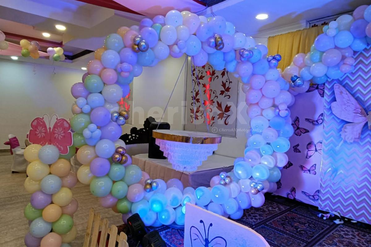 Modern elements of paper cuts, balloon arch, and sun board cutouts for an enhanced birthday experience