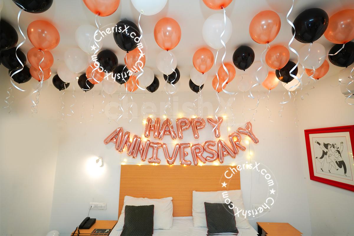 The text engraved in rose gold foil with black white and rose gold balloons hanging from the ceiling just lights up the ambience