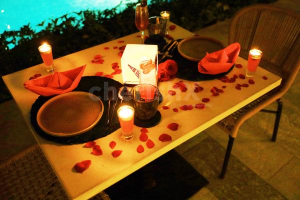 The candles and rose petals added to your poolside table adds love to the air