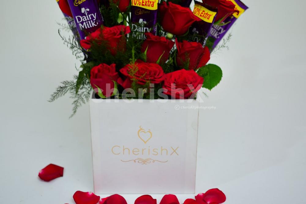 The chocolate and roses are arranged as a flower bouquet.
