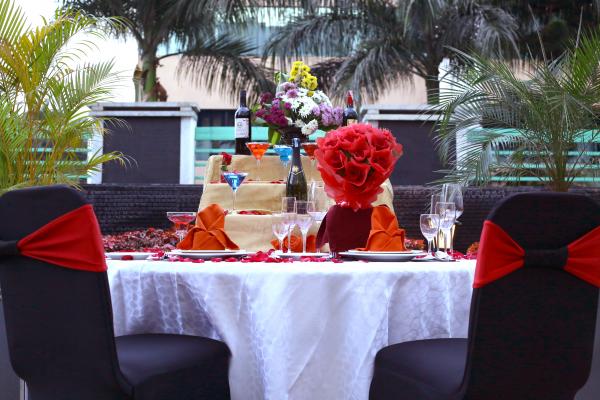 The table is beautifully decorated with balloons and roses to surprise your partner