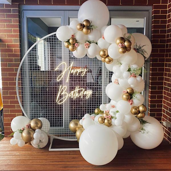 The white mesh stand with decorative balloons looks elegant