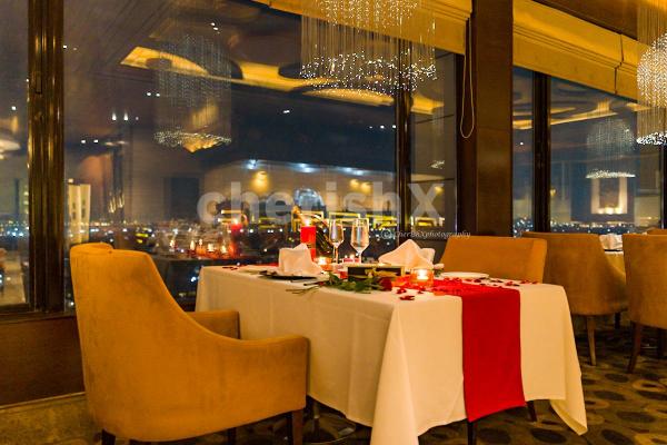 The  Romantic Dinner Table is Adorned with Rose Petals and Flickering Candles.